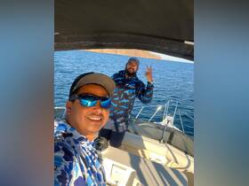 Two friends enjoy a fun moment aboard a boat, showcasing camaraderie and the joy of being on the water.
