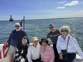 A cheerful group of friends enjoys a day out on the water, capturing memories aboard a boat with a scenic backdrop.
