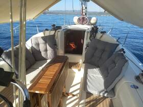 A cozy interior view of a sailboat's seating area, featuring plush cushions and a wooden table, perfect for relaxing while enjoying the serene ocean views.