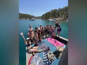 A lively group of friends enjoys a sunny day on a pontoon boat, celebrating and having fun in the water — perfect for summer adventures and memorable gatherings.