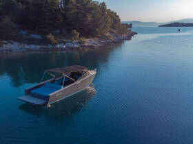 A sleek boat glides through calm waters, surrounded by lush greenery, showcasing the perfect setting for a serene day on the water.