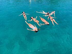 A group of friends enjoys a relaxing day floating in crystal-clear waters, perfect for summer fun and memorable outings.