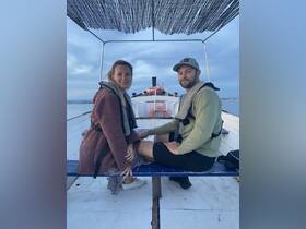 A couple enjoys a cozy moment aboard a boat, perfect for romantic outings or sunset cruises on the water.
