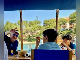 A cheerful group enjoys a meal on a boat, capturing a fun moment together — perfect for family outings and memorable experiences on the water.