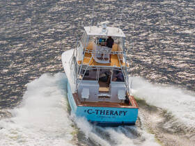 A striking aerial view of the C-Therapy boat cruising through the water, showcasing its sleek design and powerful performance.