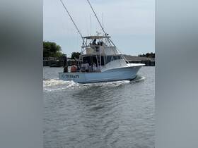 The fishing boat 'C-Therapy' is underway with a group of people on board, showcasing a lively day on the water perfect for fishing adventures.