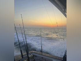 A stunning sunset view from a fishing boat, showcasing the tranquil ocean and the excitement of a fishing adventure.