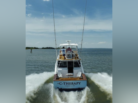 The C-THERAPY boat speeds through the water with guests onboard, showcasing the thrill of a day on the water in Corolla, NC.