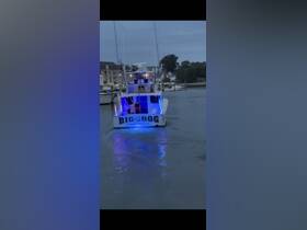 The 'Big Dog' boat lights up the water as it cruises through Virginia Beach, creating a vibrant atmosphere perfect for nighttime adventures.
