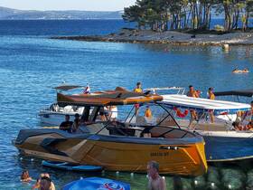 A lively scene at a beautiful bay with multiple boats and people enjoying the water, perfect for summer fun and relaxation.