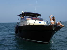 A woman enjoys the sun on the bow of a boat, showcasing a perfect day on the water. Ideal for highlighting leisure and relaxation during a boating trip.