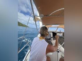 A woman skillfully steers a sailboat through beautiful ocean waters, showcasing the joy of sailing and adventure on the open sea.