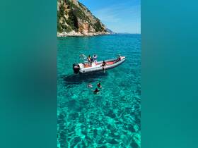 A lively group enjoys a sunny day on the water, with some swimming and others relaxing on a boat in crystal-clear waters, perfect for family fun and summer adventures.