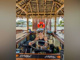 A young girl confidently takes the helm in a boat's interior, showcasing the fun and adventurous spirit of boating. The vibrant setting highlights the joy of nautical experiences.