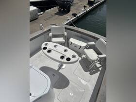 Interior view of a boat's helm area featuring seating and a console, ideal for fishing or leisure outings.