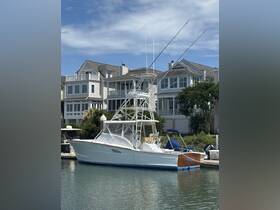 A sleek fishing boat docked in a serene marina, showcasing its impressive structure against a backdrop of coastal homes.