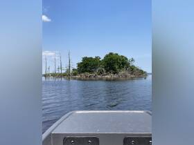 A scenic view of an island surrounded by calm waters, captured from the bow of a boat — perfect for nature lovers and adventure seekers exploring tranquil waterways.