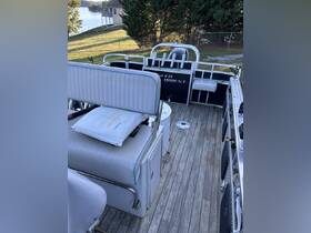 Interior view of a pontoon boat showcasing comfortable seating and helm area, perfect for relaxing and enjoying time on the water.