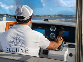 A skilled captain navigates the helm of a deluxe boat, showcasing the modern console and controls — perfect for luxury boating experiences.
