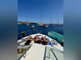 Three friends enjoy sunbathing on the deck of a boat, surrounded by a beautiful blue sea and other vessels — a perfect summer day on the water.