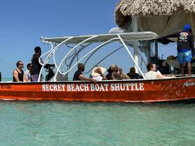 A lively group enjoys a boat shuttle to Secret Beach, soaking in the sun and ocean views — perfect for a fun day out on the water.