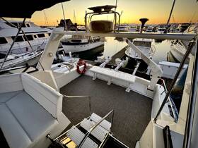 A well-appointed interior view of a boat's seating area and helm, showcasing a serene marina setting at sunset.