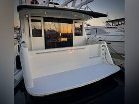 A sleek view of the back of a yacht docked at sunset, showcasing its modern design and tranquil marina setting.