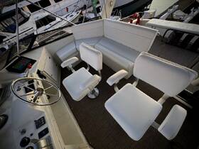 An inviting view of the helm and seating area inside a boat, showcasing comfortable white chairs and a well-equipped dashboard — perfect for a day on the water.