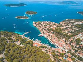A stunning aerial view of a picturesque harbor surrounded by lush islands and vibrant coastal homes, showcasing the beauty of the Croatian coastline.
