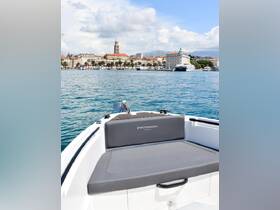 A sleek view of the Protagon yacht's seating area, showcasing the stunning waterfront scenery of a coastal town in the background.