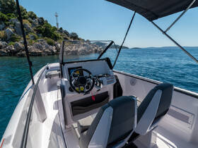 The interior view of a sleek boat helm showcases modern seating and controls, perfect for navigating the open waters.