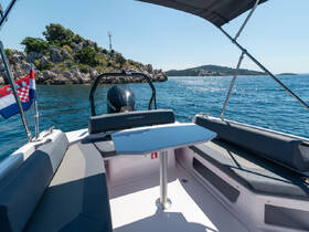 A sleek interior view of a modern boat showcasing comfortable seating and a helm, perfect for enjoying a day on the water.