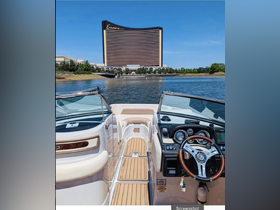A detailed view of the helm and interior of a boat, showcasing the sleek design and controls, with the Encore hotel in the background.