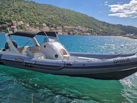 A sleek speedboat anchored in clear turquoise waters, showcasing its modern design against a picturesque coastal backdrop.