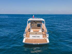 A stunning view of the 'Pura Vida' yacht cruising through clear blue waters, showcasing its elegant design and spacious deck — perfect for luxury outings on the sea.