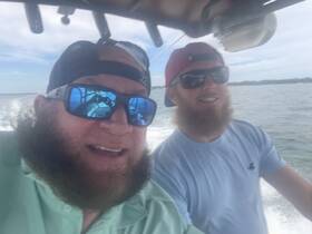 Two friends enjoy a fun day on the water, capturing the excitement of boating with smiles and camaraderie.