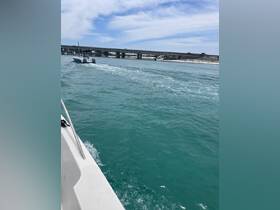 A speedboat navigates through clear turquoise waters, showcasing the beauty of a day on the water.