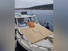A cozy seating area on the deck of a boat, featuring a comfortable cushion and equipment ready for a day on the water.
