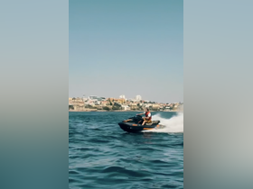 A thrilling moment captured as a rider speeds across the water on a jet ski, showcasing the excitement of water sports against a scenic backdrop.