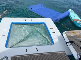 A relaxing jacuzzi on a boat with a floating mat and paddleboard nearby, perfect for enjoying a day on the water.