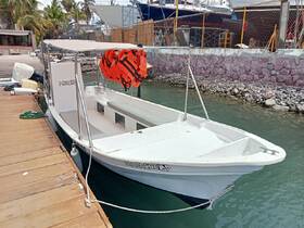 A side view of a small boat docked at the marina, featuring life jackets and a clear boat name, ideal for passenger trips.