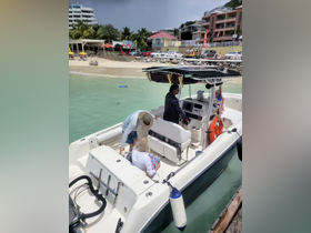A group of people aboard a boat, enjoying a sunny day at the beach, with a vibrant shoreline in the background — perfect for a relaxing day on the water.