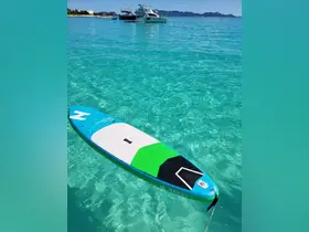A vibrant paddleboard floats in crystal-clear waters, perfect for enjoying water activities and exploring beautiful coastal areas.
