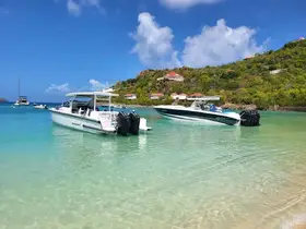 Two sleek speedboats anchored in crystal-clear turquoise waters, showcasing a perfect day for boating adventures in a picturesque setting.