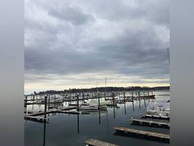 A serene view of a marina filled with various boats docked under a cloudy sky, showcasing the tranquil atmosphere of a boating community.
