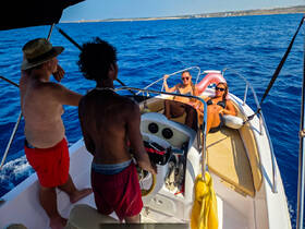 A group of friends enjoys a sunny day on the water, relaxing on a boat while taking in the beautiful ocean views — perfect for a fun day out at sea.