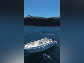 A scenic view of a boat cruising on clear waters, with a person at the helm, showcasing the beauty of a day on the water.