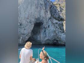 A couple enjoys a scenic boat ride near a stunning cave, capturing the essence of adventure and exploration on the water.
