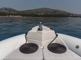 A clear view of the front of a boat, showcasing its sleek design against a tranquil water backdrop, ideal for exploring coastal destinations.
