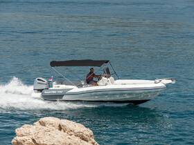 A speedboat glides through clear waters with a driver at the helm, showcasing the thrill of boating adventures on the open sea.
